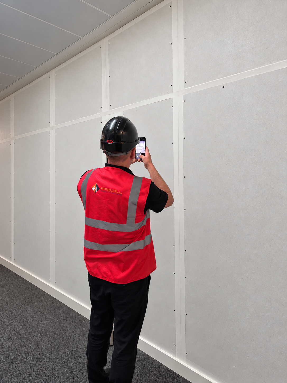 Site Manager Inspecting Fire Rated Wall