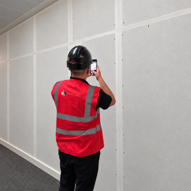 Site Manager Inspecting Fire Rated Wall